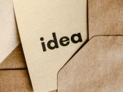 A close-up of a brown envelope containing a card labeled 'idea,' symbolizing creativity and innovation.
